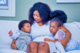 a woman and two children sitting on a couch