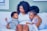 a woman and two children sitting on a couch