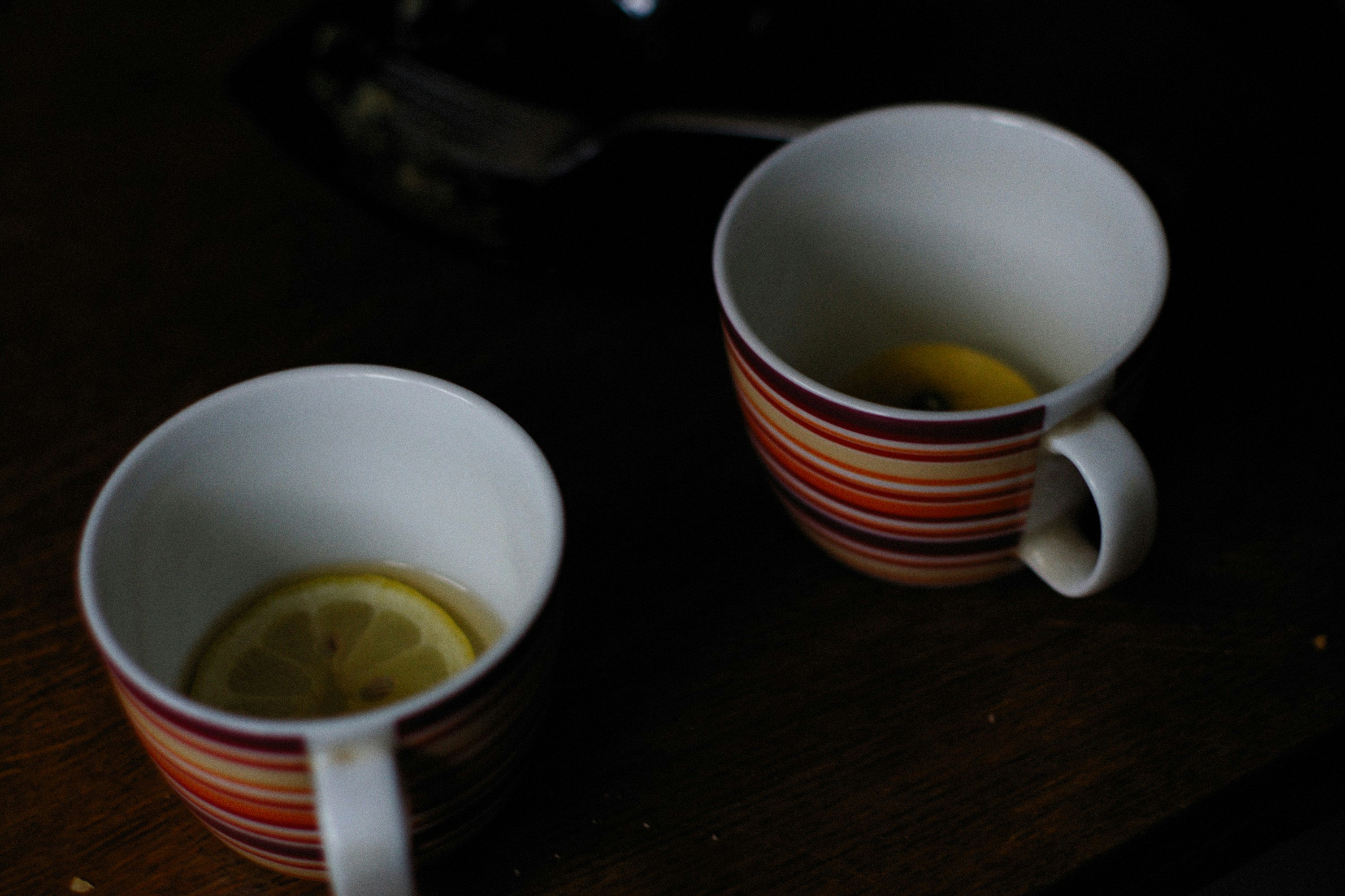 two cups of tea with a lemon slice in them