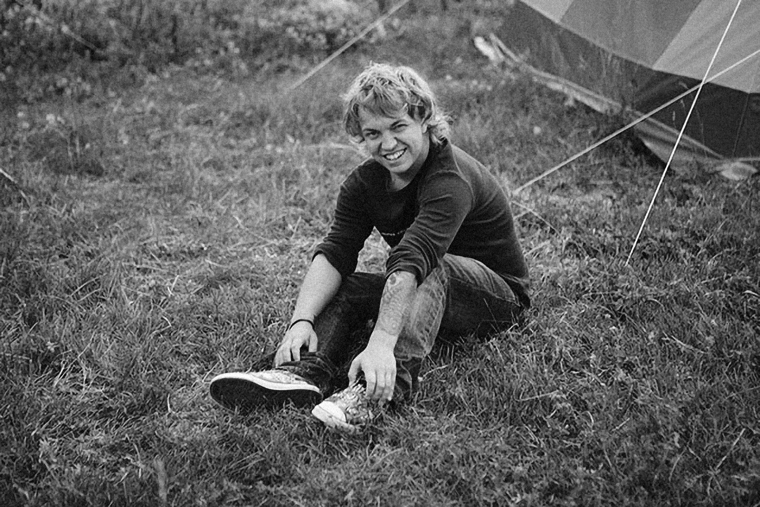 a black and white photo of a person sitting in the grass