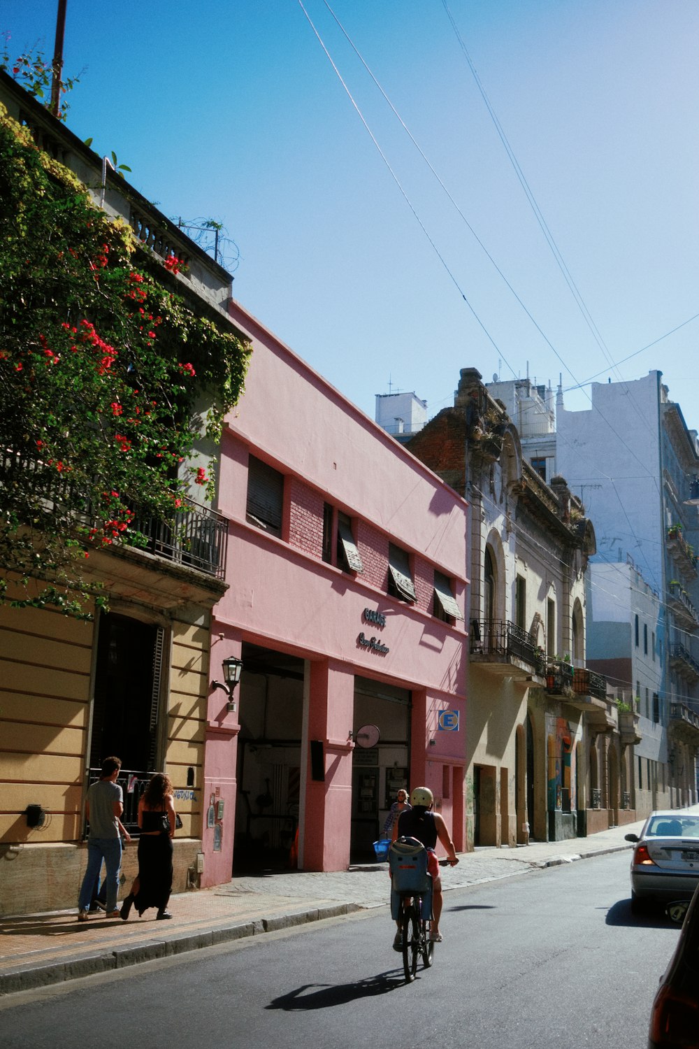 a man riding a bike down a street next to tall buildings