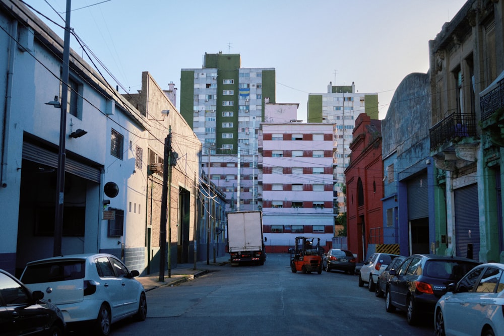 a city street lined with tall buildings and parked cars