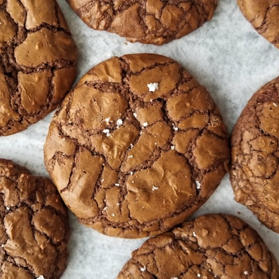 A plate of golden-brown sourdough cookies with a slightly cracked surface and sugar dusting.