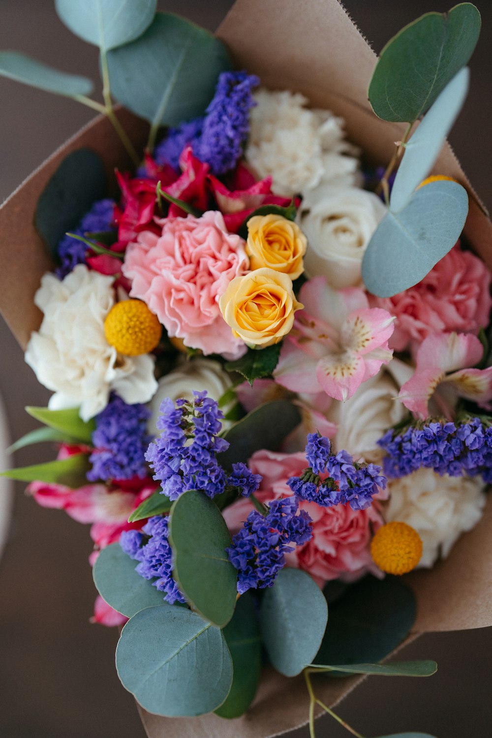 a bouquet of flowers in a brown paper bag