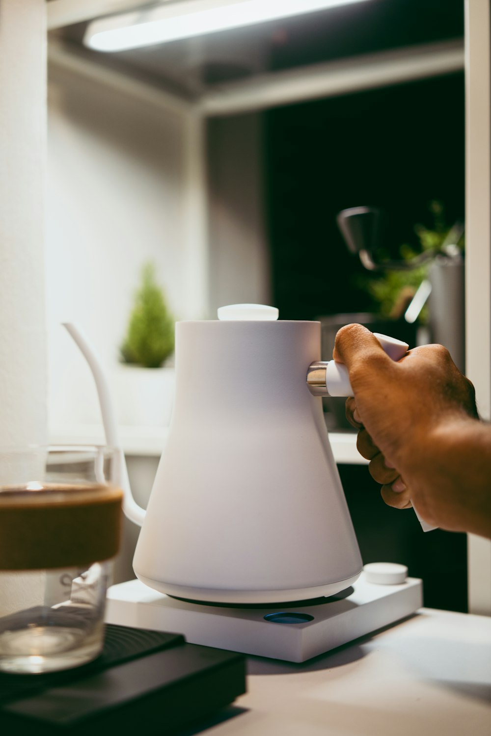 a person is holding a coffee pot on a table