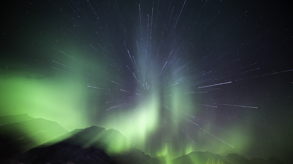 a green and white aurora bore is in the sky