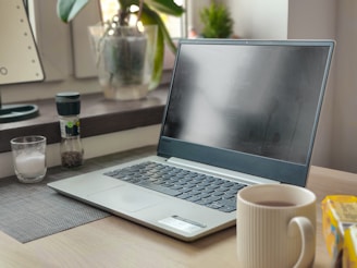 A sleek workspace with a laptop, notebook, and coffee cup, bathed in soft natural light, reflecting a modern corporate woman's financial planning.