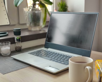 a laptop computer sitting on top of a wooden desk