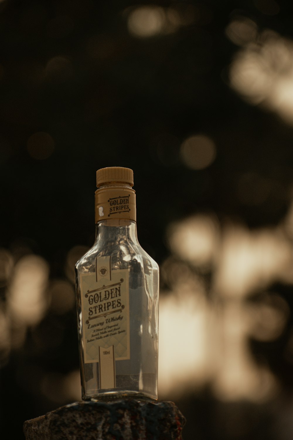 a bottle of whisky sitting on top of a piece of wood