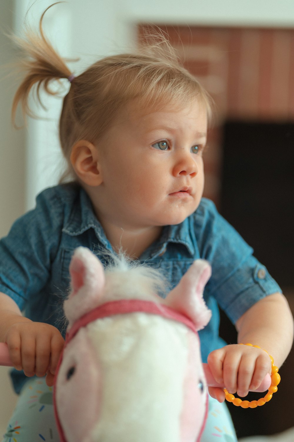 a little girl sitting on a toy horse