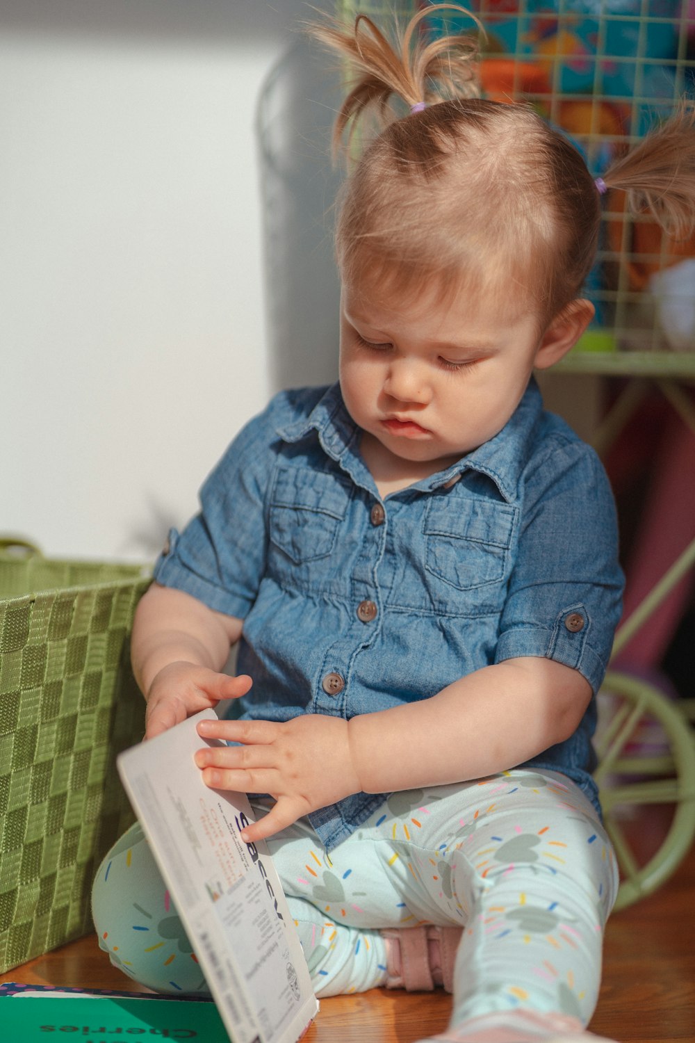 a little girl sitting on the floor reading a book