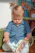 A joyful child sitting cross-legged, deeply engaged in reading a colorful storybook.