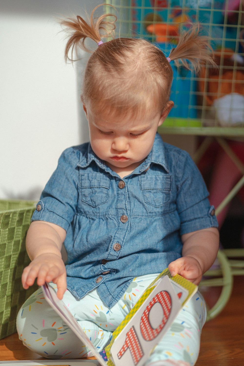 a baby sitting on the floor reading a book