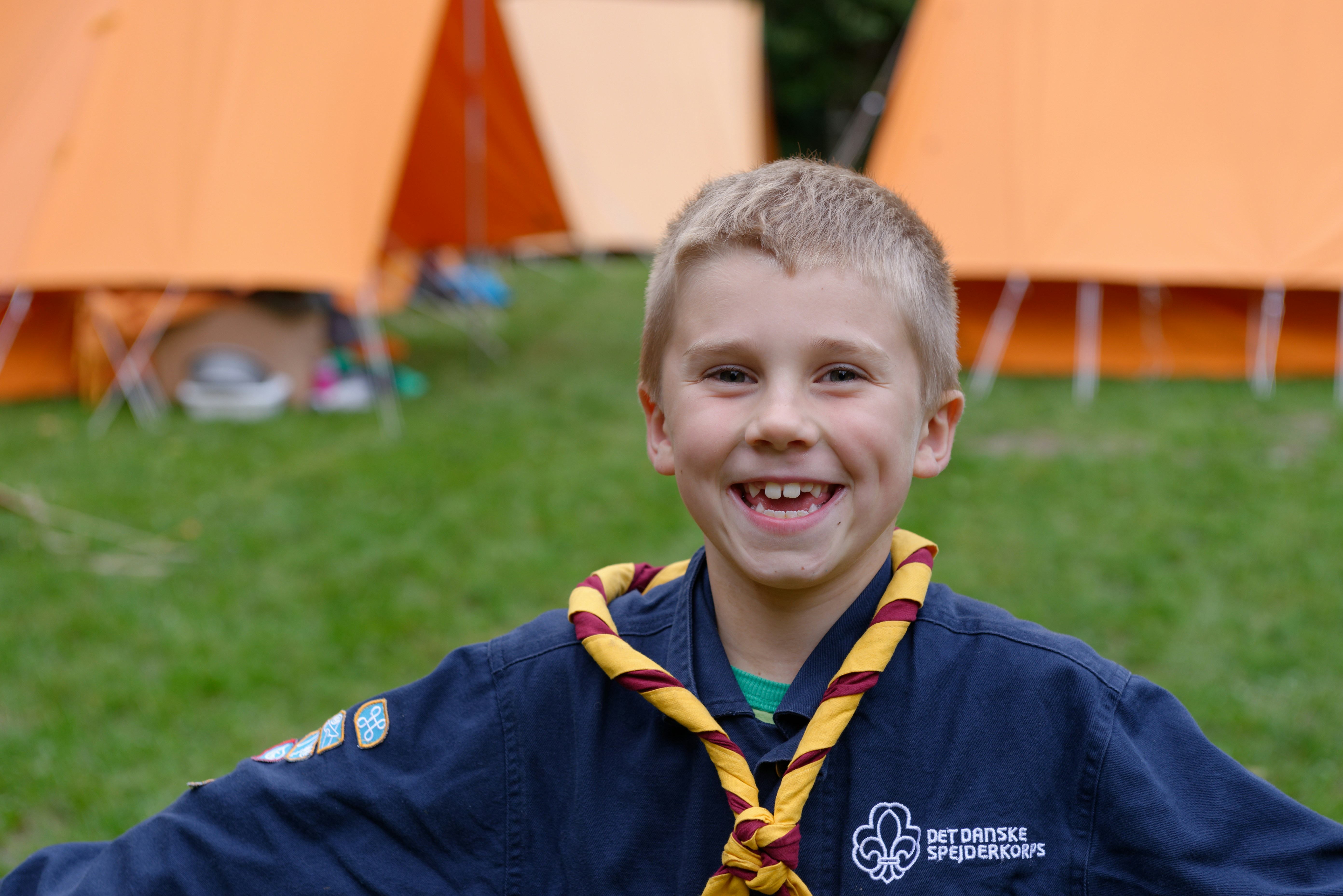 a young boy wearing a yellow and red neck tie