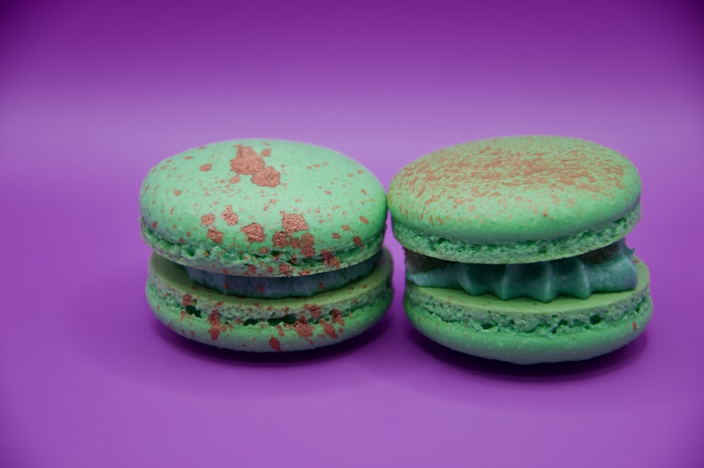 a couple of green macaroons sitting on top of each other