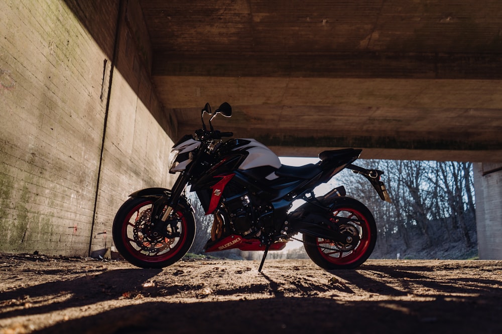 a white and black motorcycle parked under a bridge