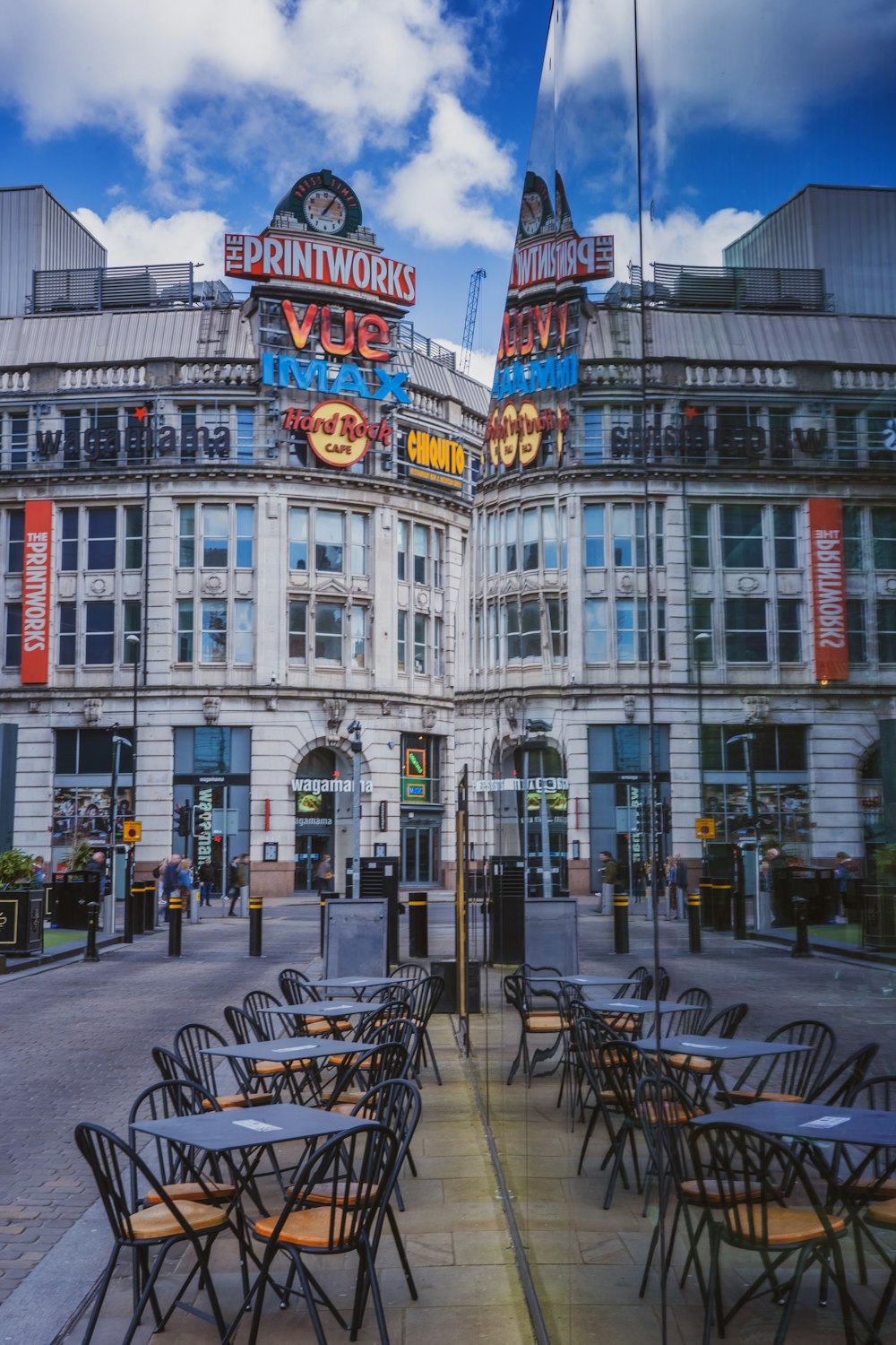 a large building with many tables and chairs in front of it