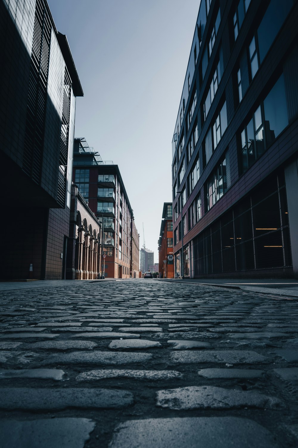 a cobblestone street with buildings in the background