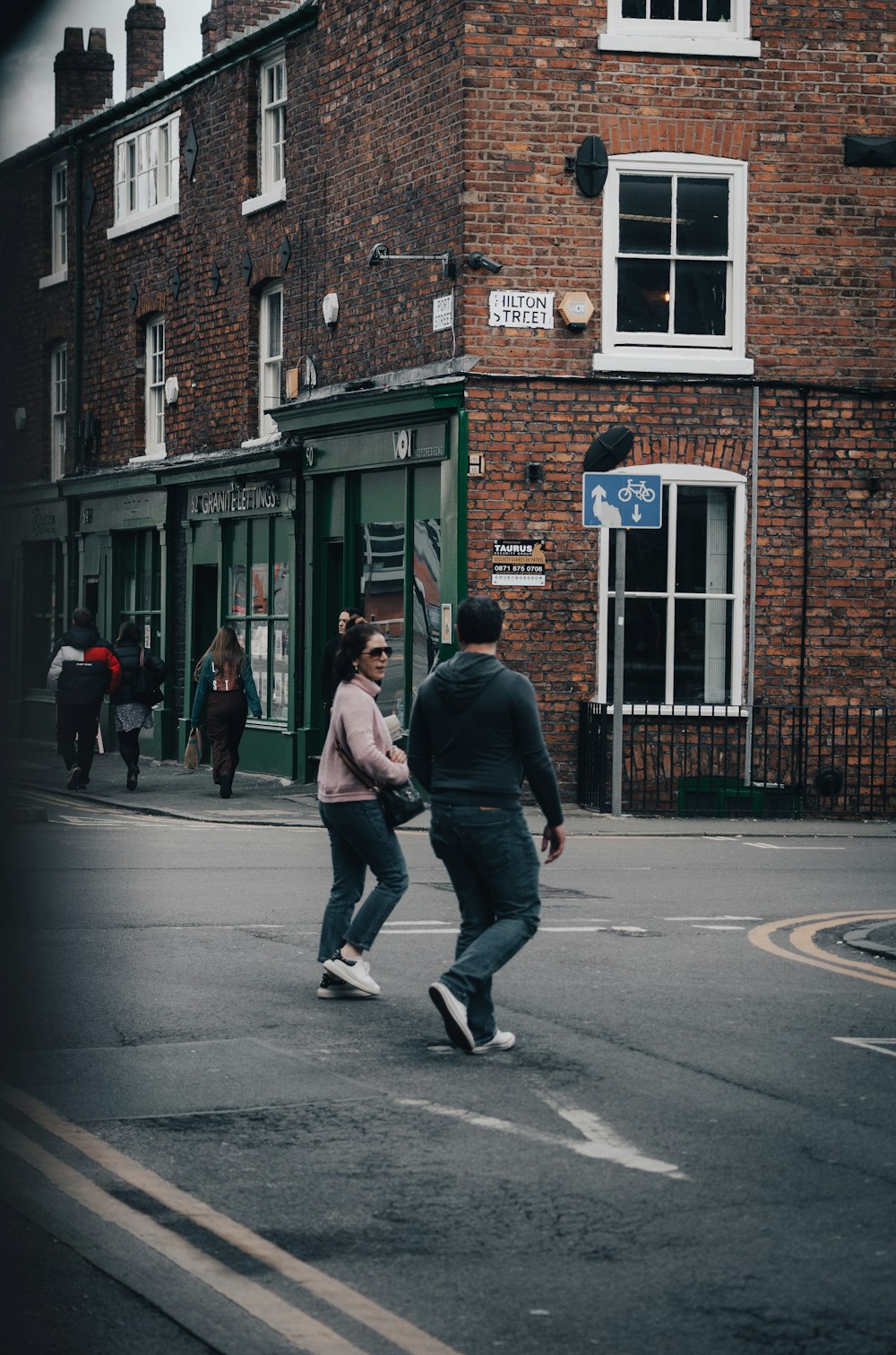 a couple of people that are walking across a street