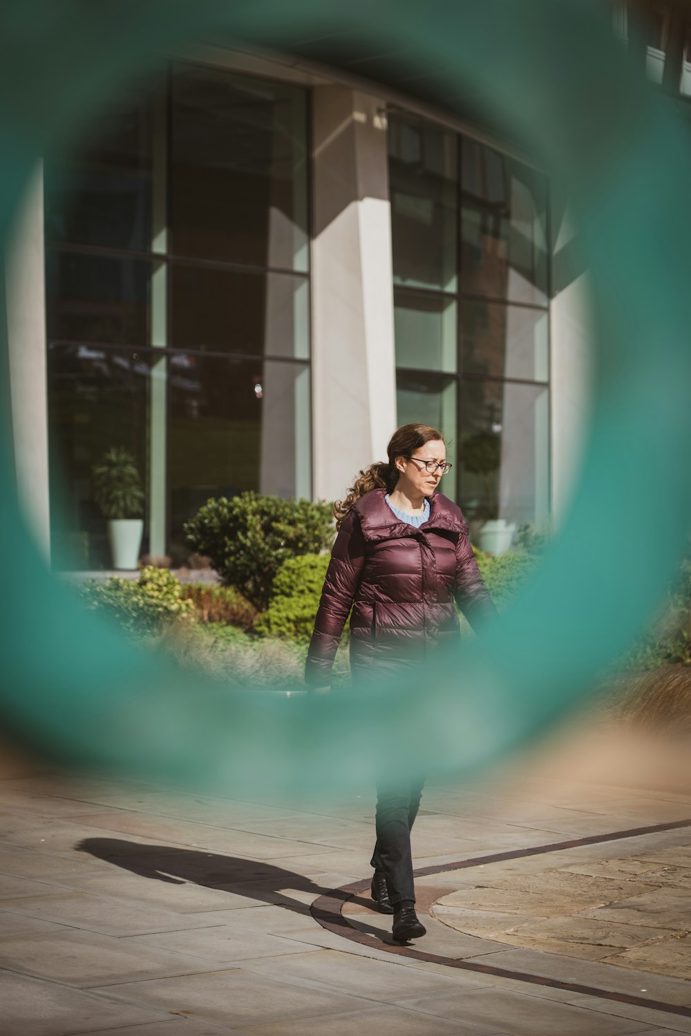 a woman walking down a sidewalk in front of a building