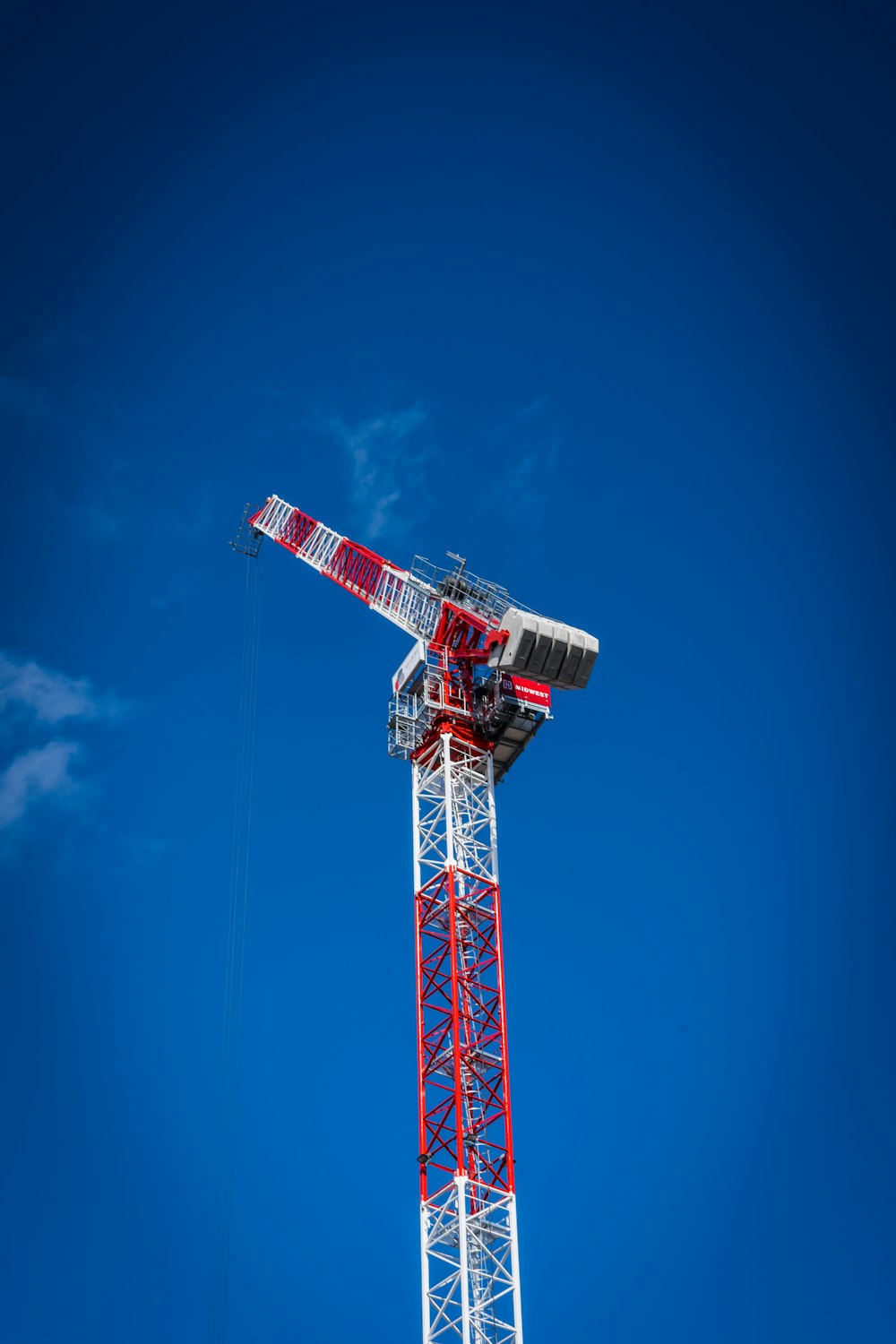 a red and white crane on a clear day