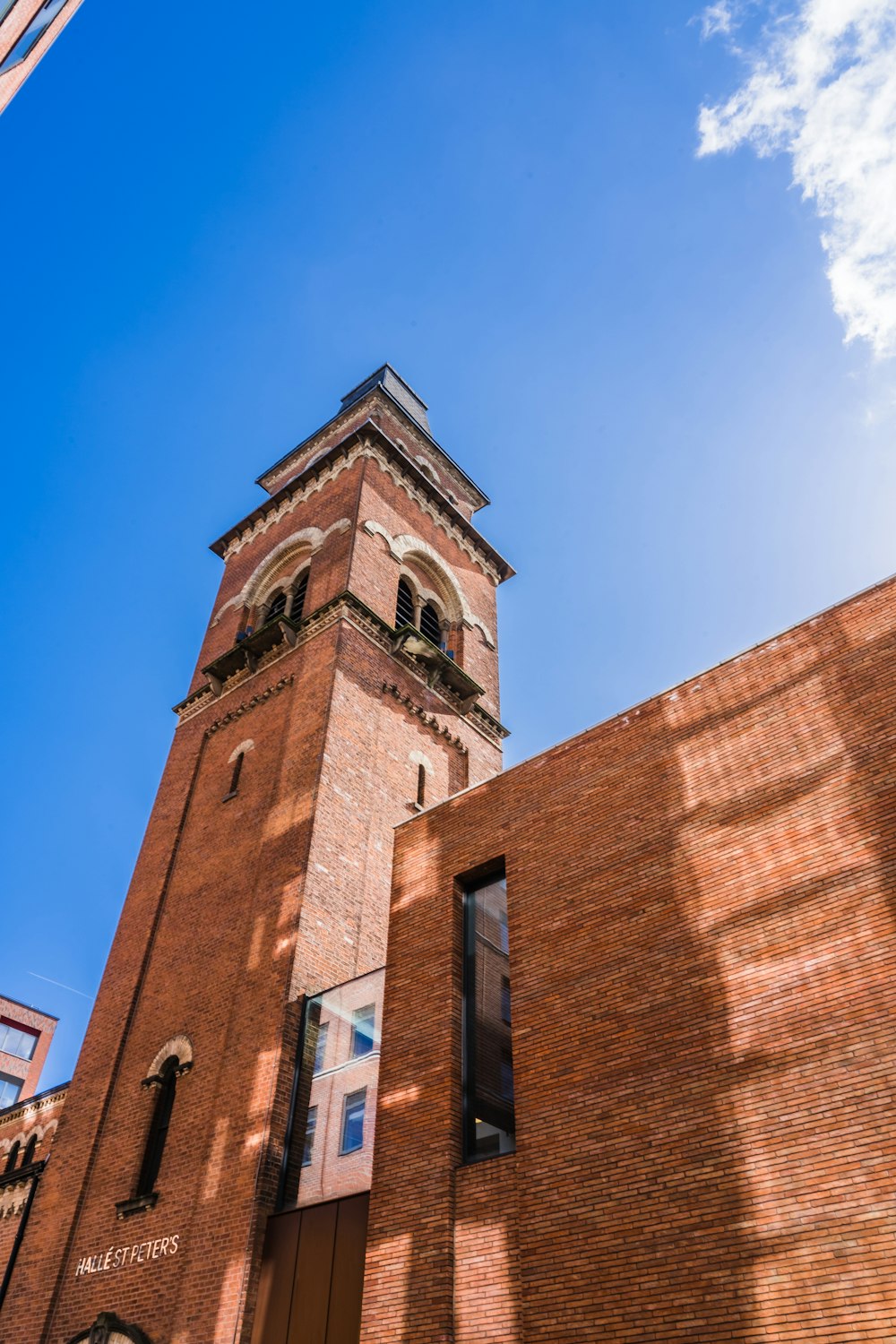 a tall brick building with a clock on it's side