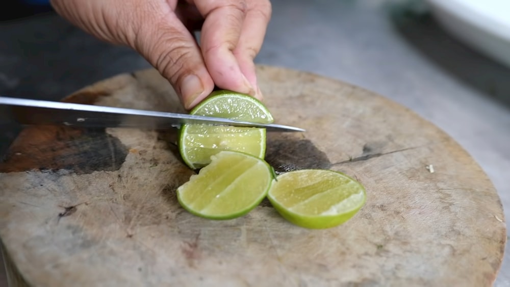 a person cutting a lime with a knife