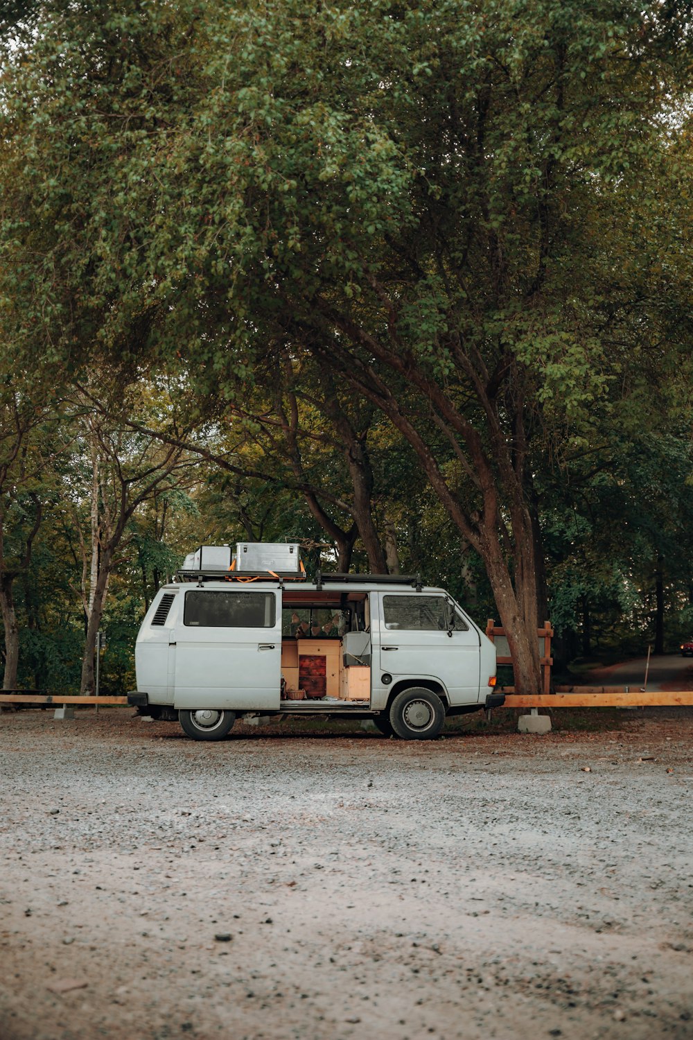 a white van parked in front of a tree