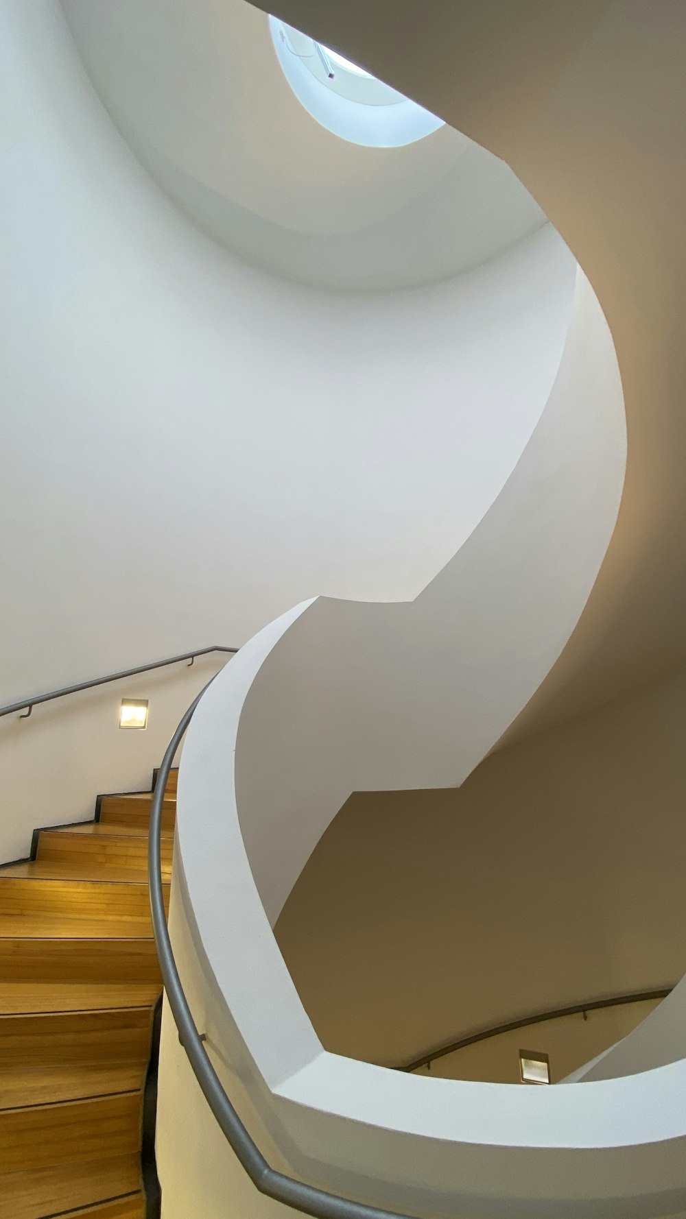 a spiral staircase in a building with a skylight