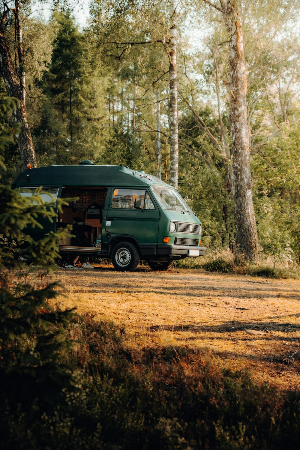 a van is parked in the middle of the woods