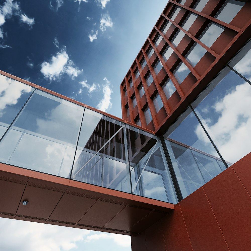 a red building with glass balconies and a sky background