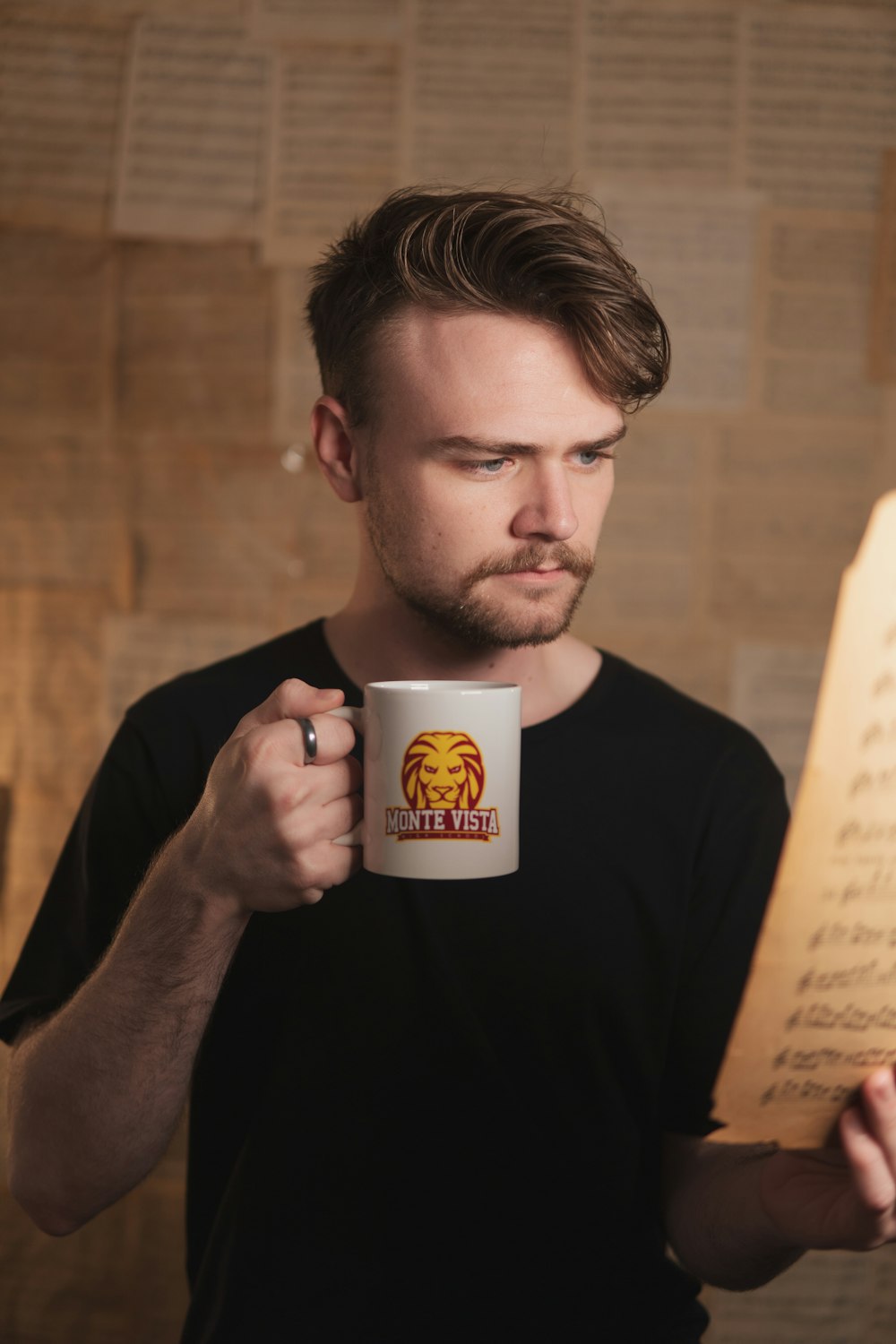 a man holding a coffee mug and a piece of paper