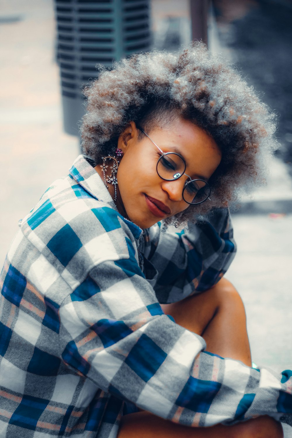 a woman with glasses sitting on the ground