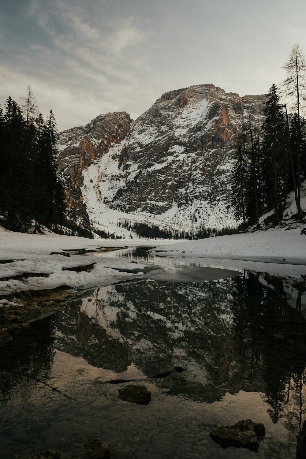 Une montagne enneigée avec un lac au premier plan