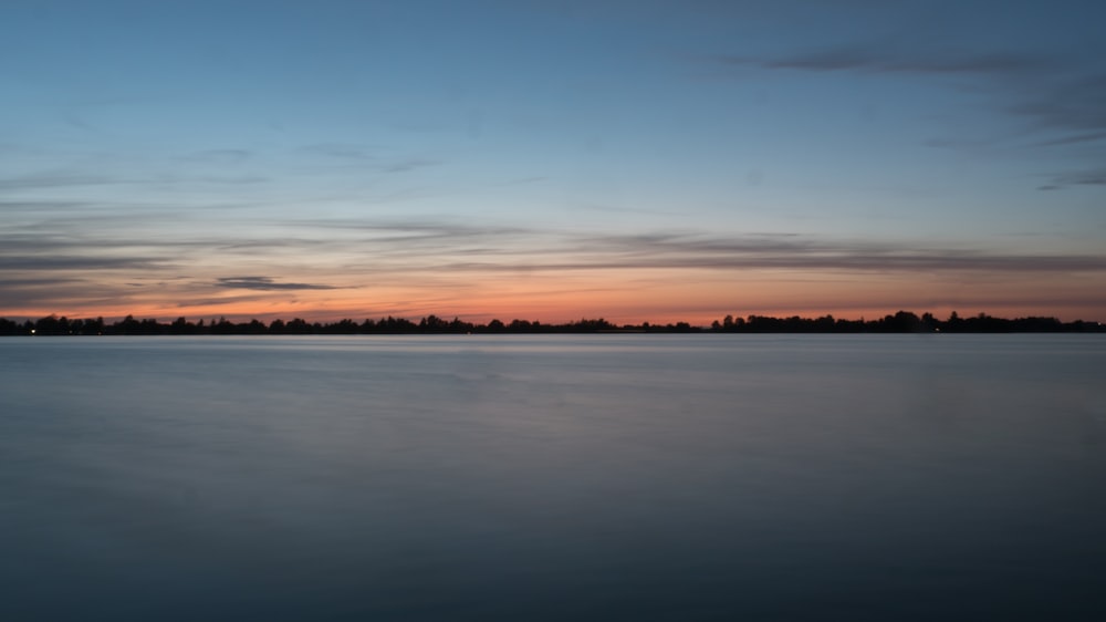 a body of water with a sky in the background