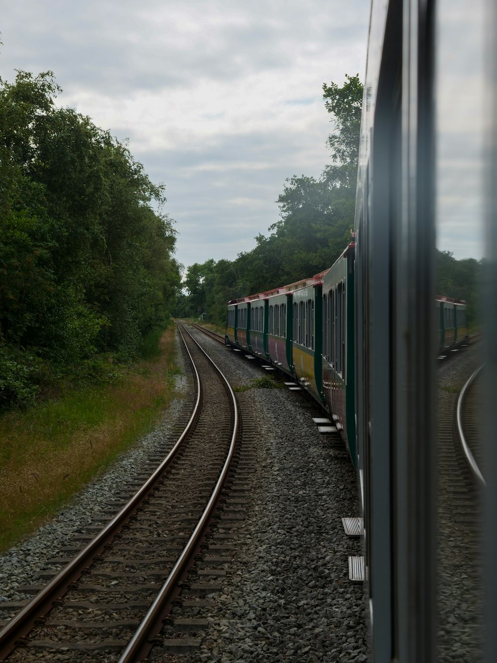 a train traveling down train tracks next to a forest