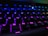 Close-up of hands typing on a sleek Strife Technologies keyboard with colorful backlighting.