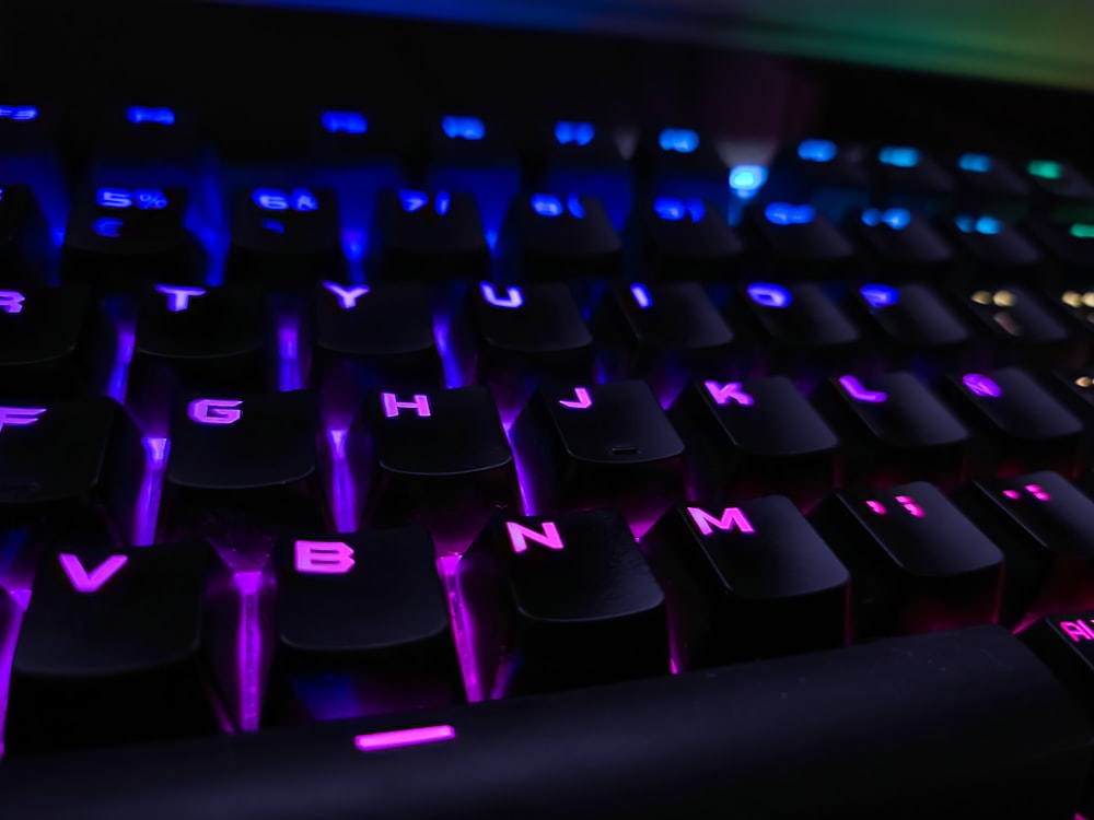 Un primer plano de un teclado con luces púrpuras y azules