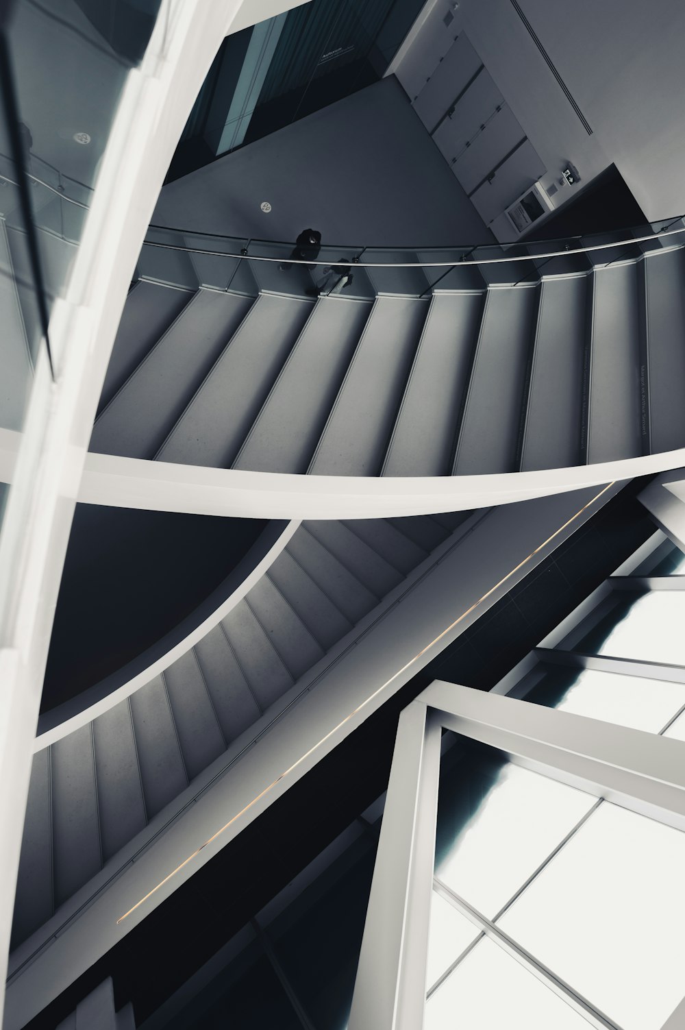 a spiral staircase in a building with a skylight