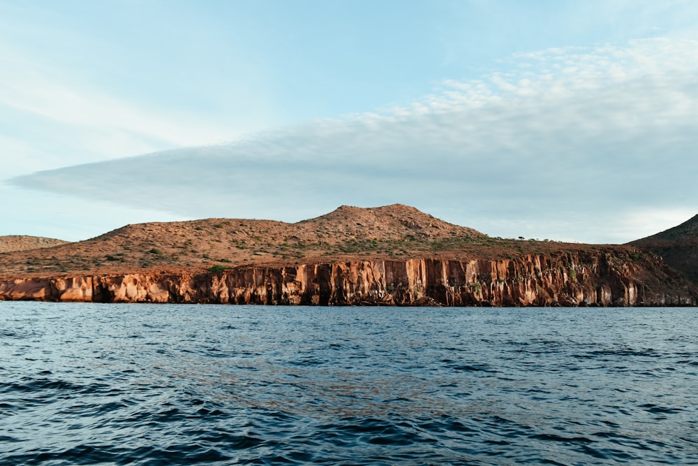 a large body of water with a mountain in the background