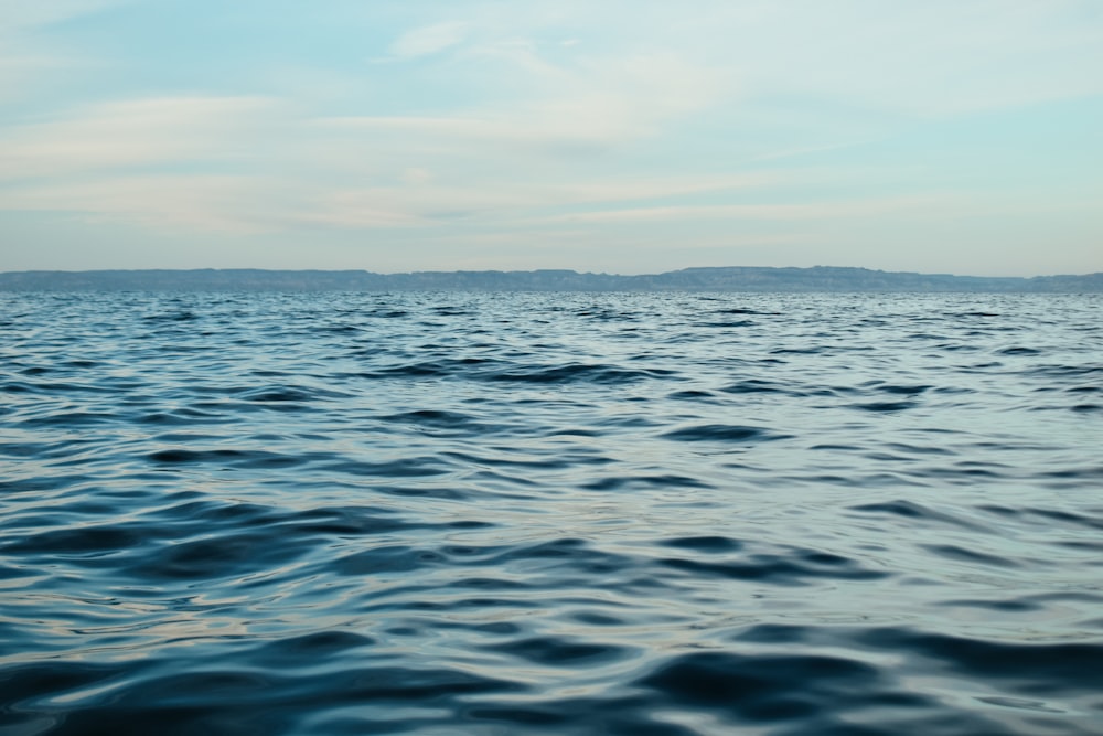 a body of water with a sky in the background