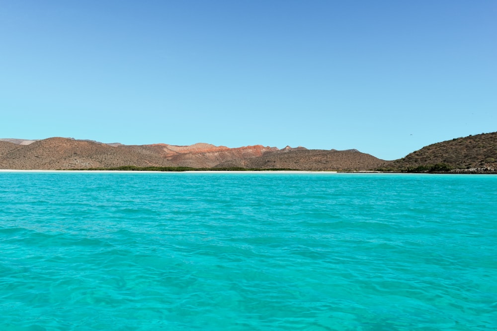 a body of water with mountains in the background