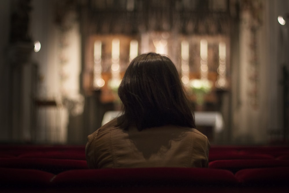 a woman is sitting alone in a church