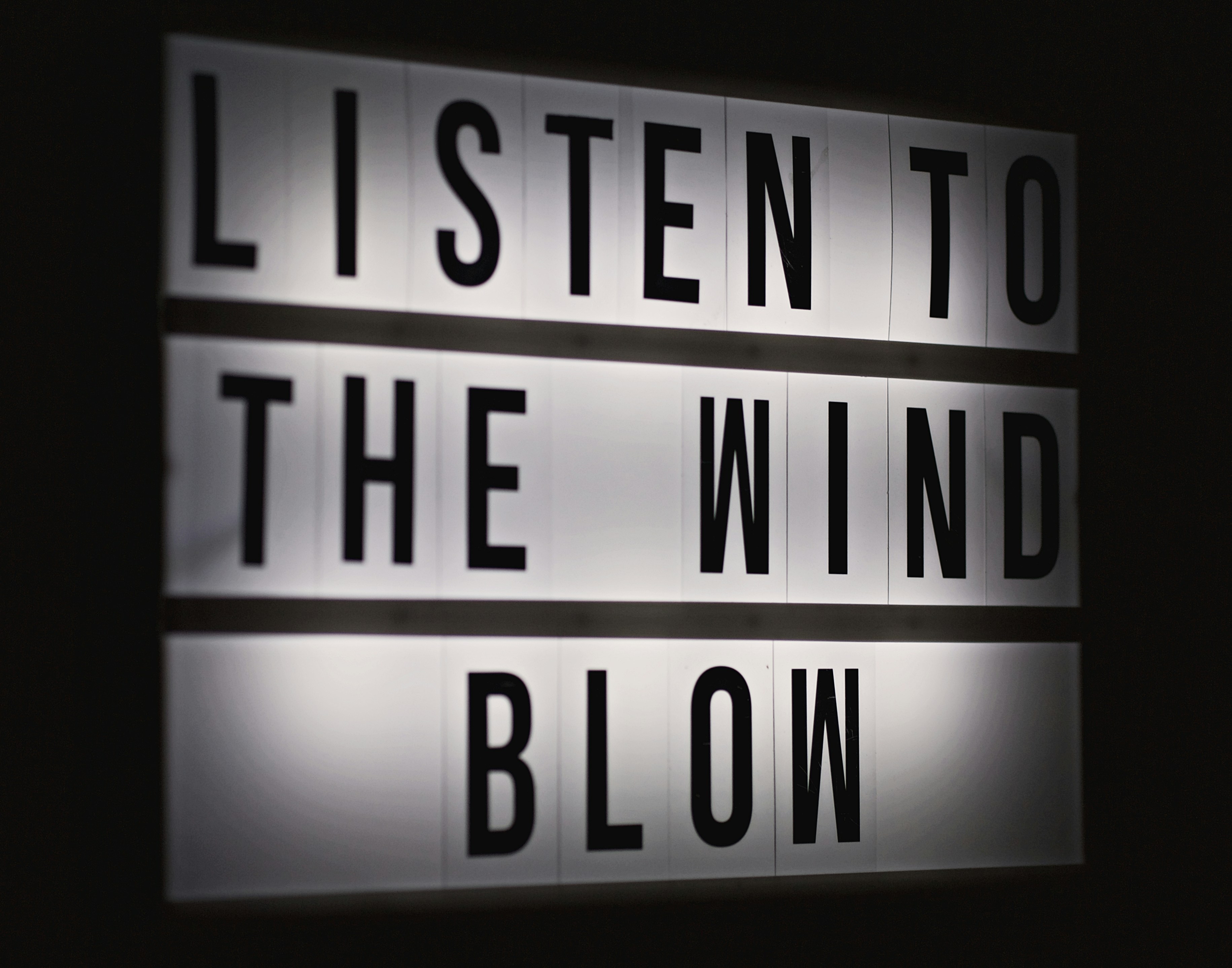 a sign that says listen to the wind and blow