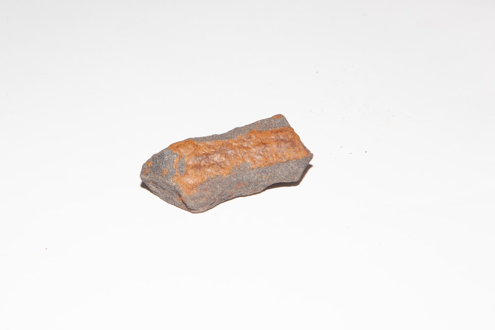 a rock sitting on top of a white surface