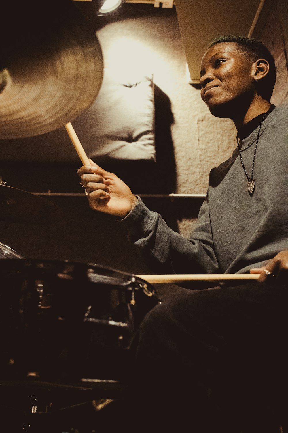 a man sitting in front of a drum set