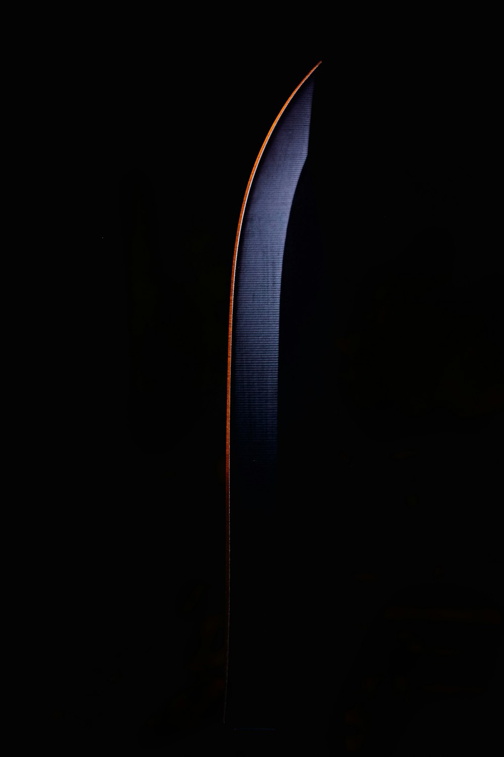 a large knife in the dark with a black background