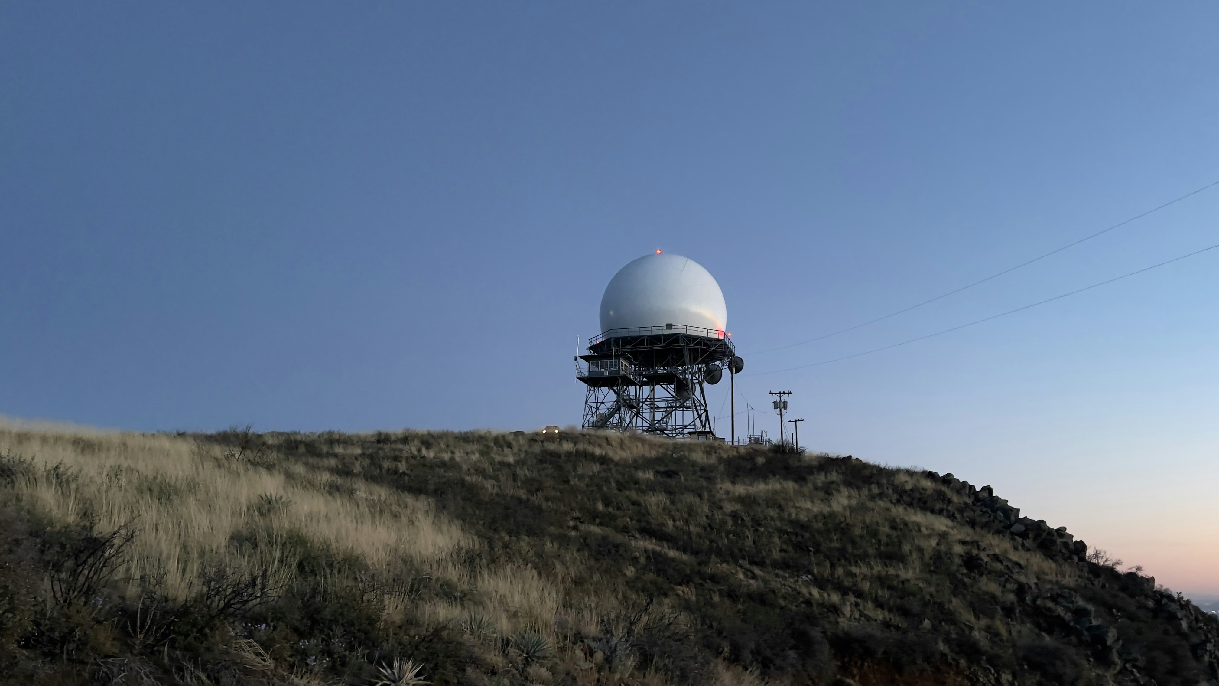 a satellite dish sitting on top of a hill