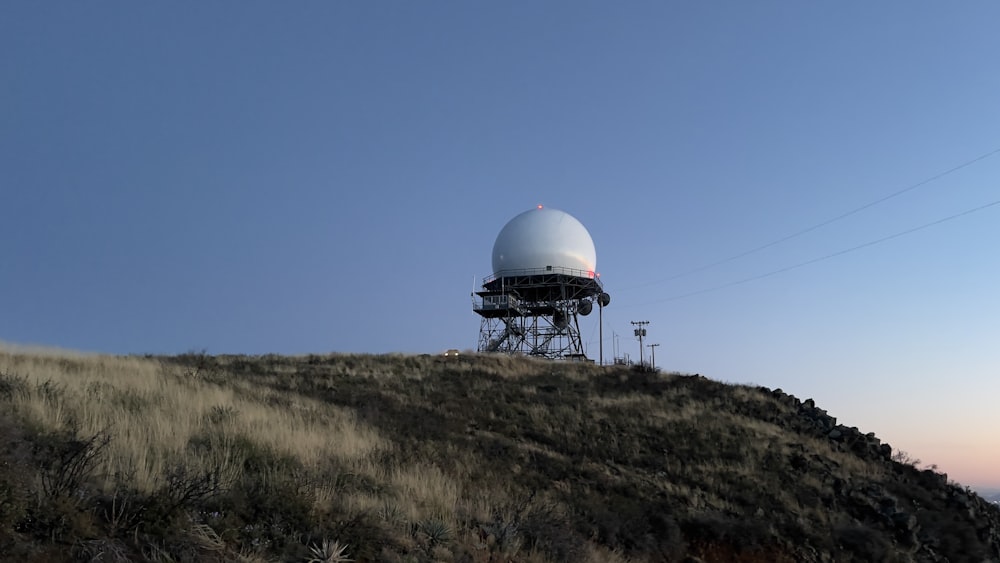 une antenne parabolique au sommet d’une colline