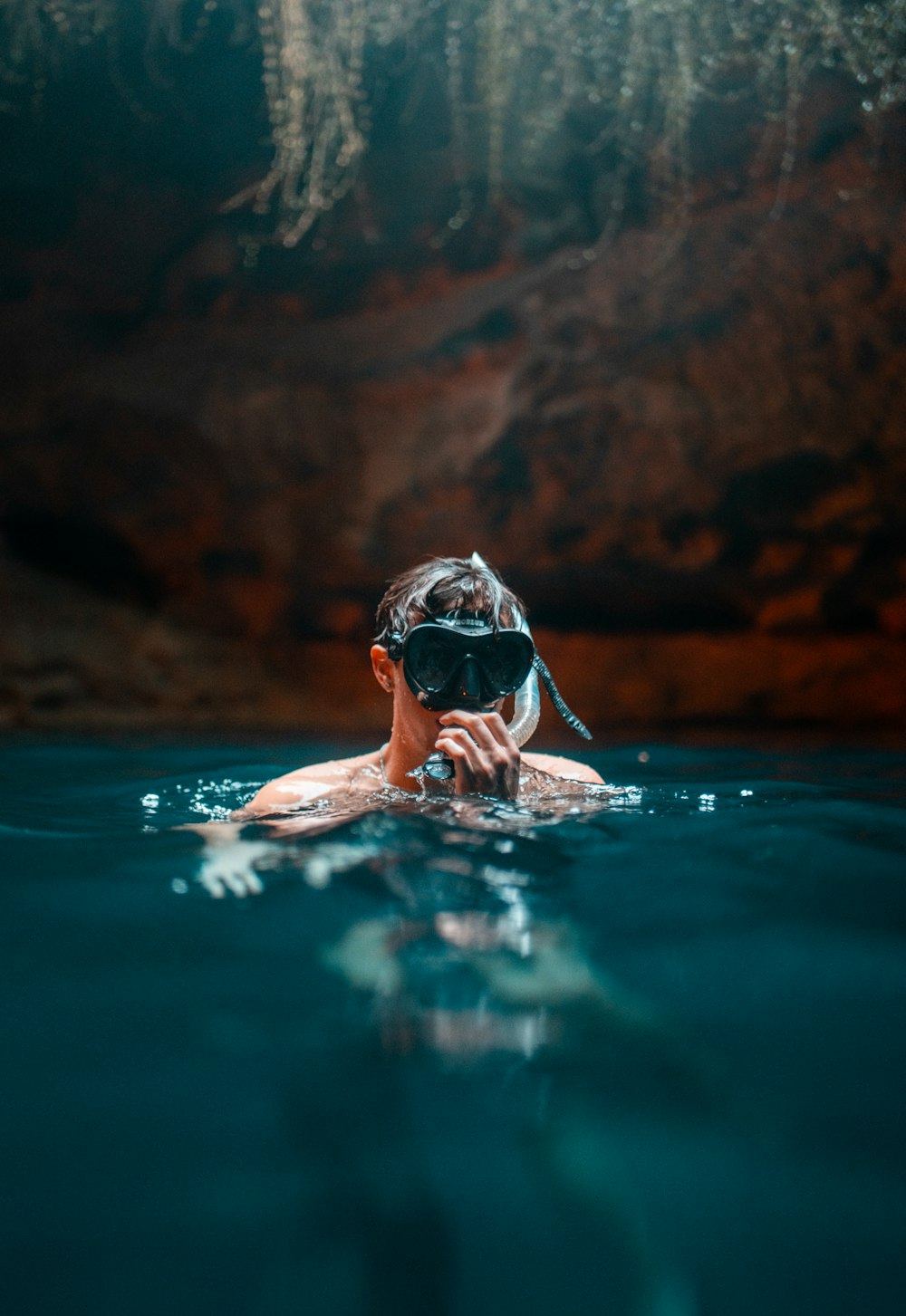 a man swimming in the water with a mask on